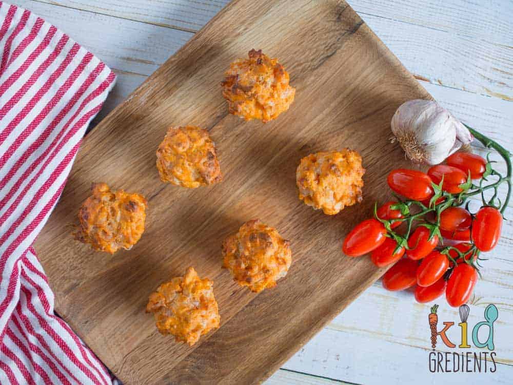 Pizza mini muffins, perfect for the lunchbox and an awesome afternoon snack. Savoury with bacon and cheese, this yummy recipe freezes well and makes 24 mini muffins!