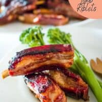 sticky honey soy lamb riblets on a plate with broccolini