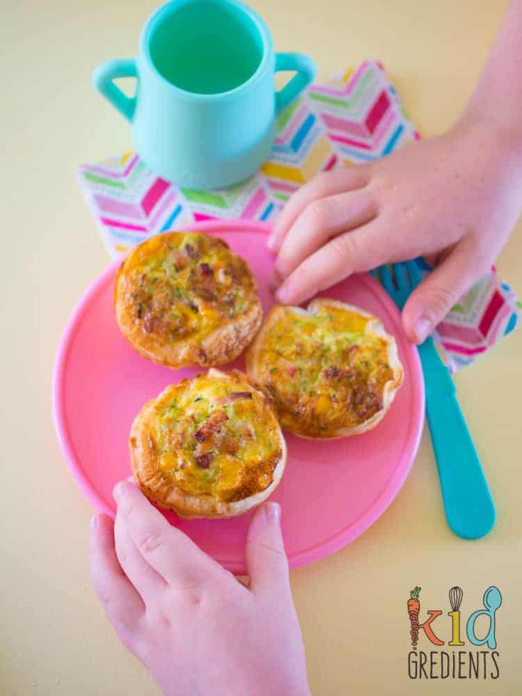 Lunchbox bacon and veggie quiches with kids hands reaching in