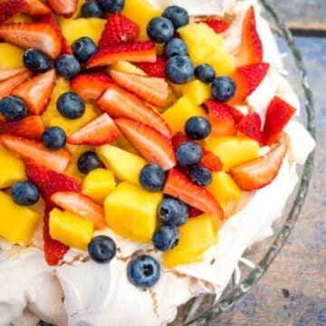 classic aussie pavlova topped with berries and fresh fruit