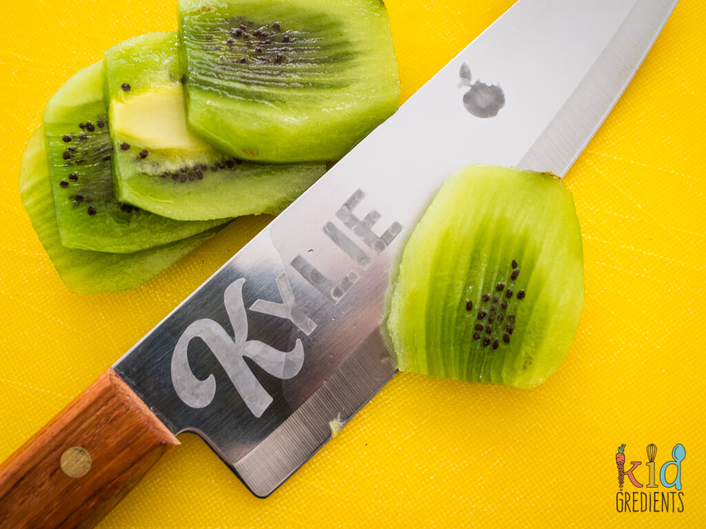 a kiwi fruit being cut by the etched knife