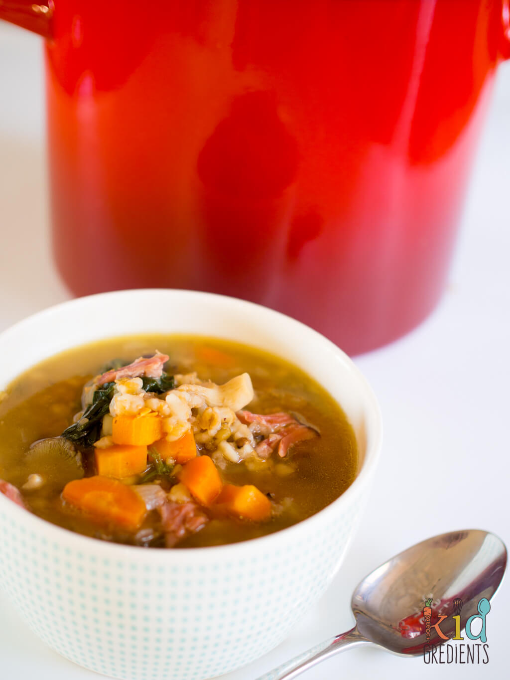 A bowl of soup with meat and vegetables in a cup