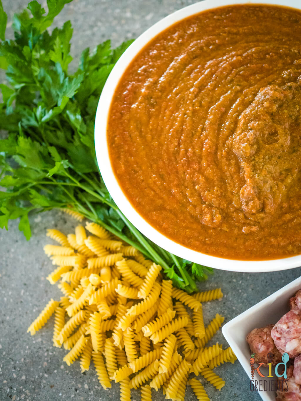 A bowl of food, with Sauce and Pasta