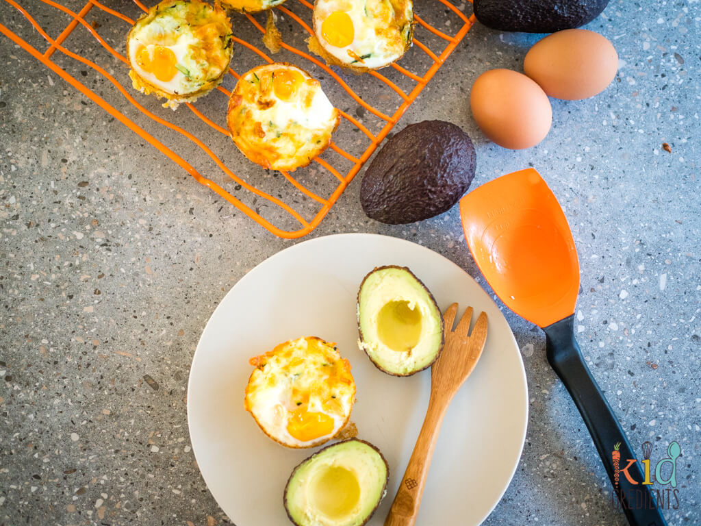 cooked egg cup on a plat with a halved avocado