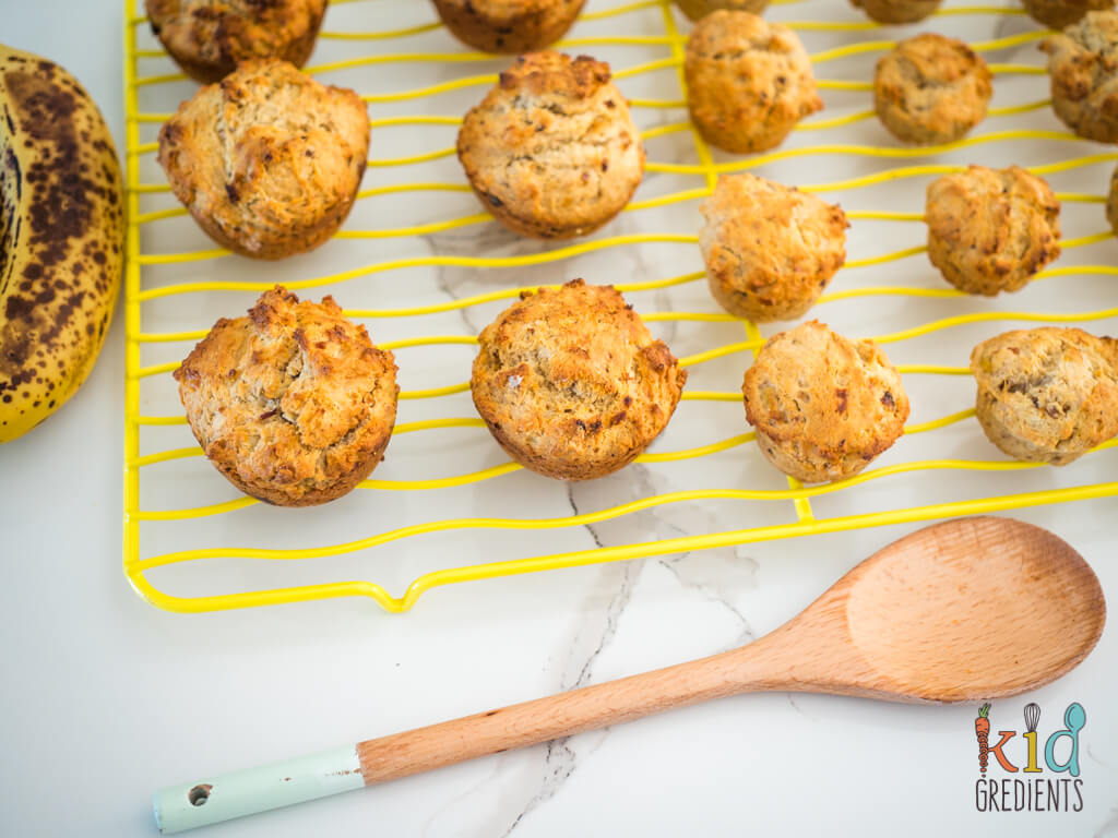 muffins, mini and large on a wire rack with a wooden spoon in front of them