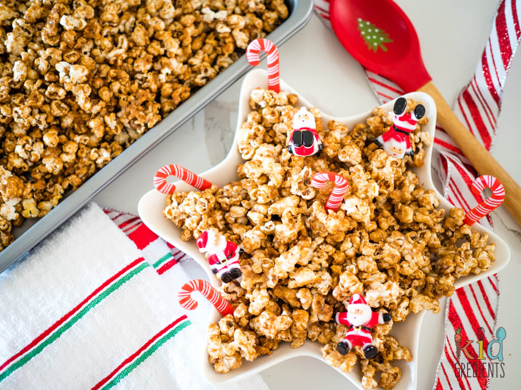 caramel gingerbread popcorn in a star shaped bowl with santas and candy canes