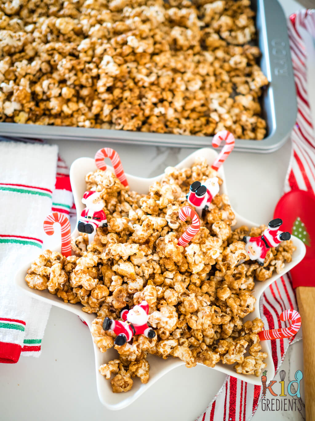 caramel gingerbread popcorn on a tray and in a star shaped bowl with santas