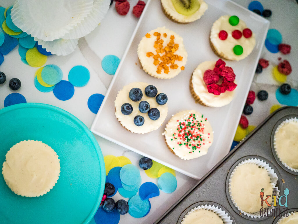 no bake mini cheesecakes on a tray with decorations and in the muffin pan pan in liners
