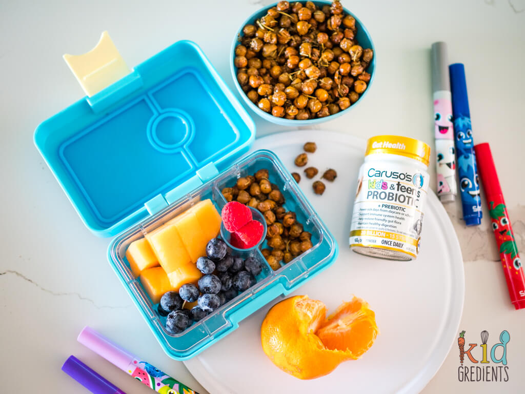 roasted chickpeas in a lunchbox and a bowl, surrounded by textas, a mandarin and caruso's kids and teens probiotics