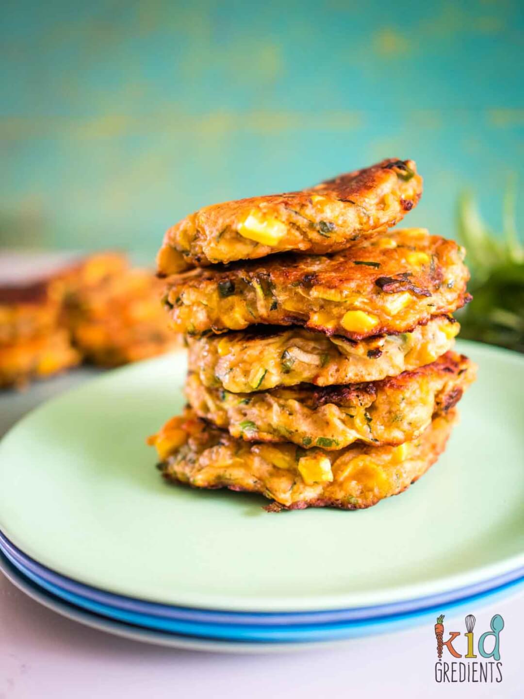 Corn and Zucchini Fritters stacked on a green plate