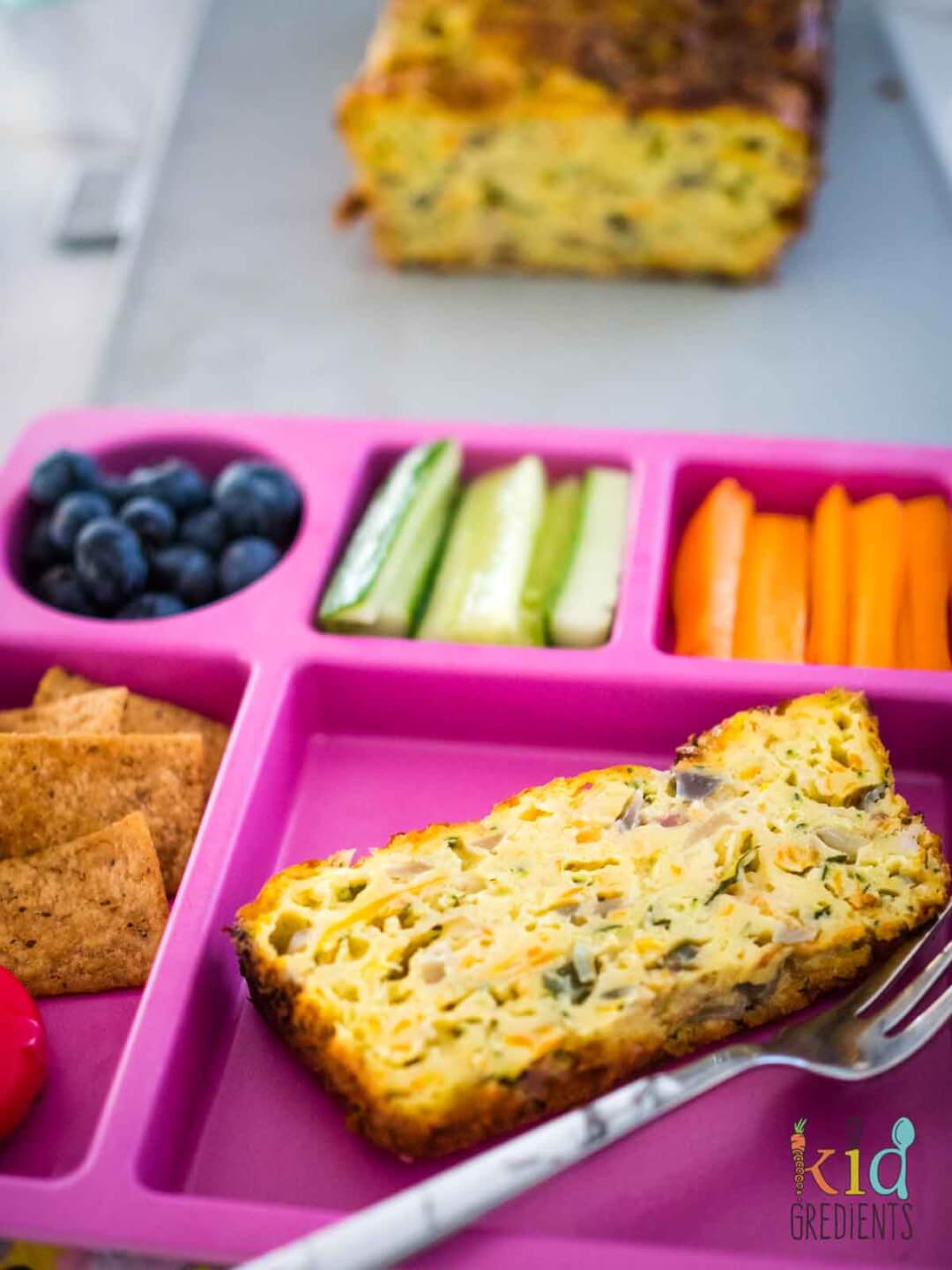 easy zucchini slice on a plate with veggies, cheese and crackers