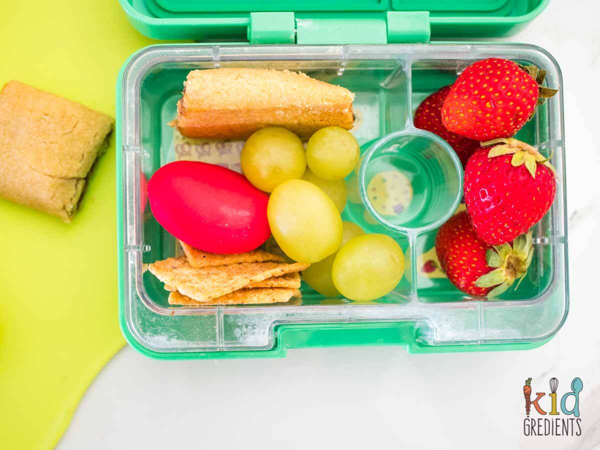 apple pie cookies in a lunchbox, with straberries, grapes, crackers and cheese