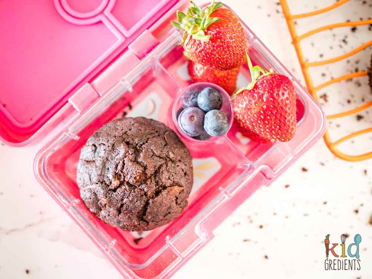 chocolate zucchini muffin in a lunchbox with blueberries and starwberries