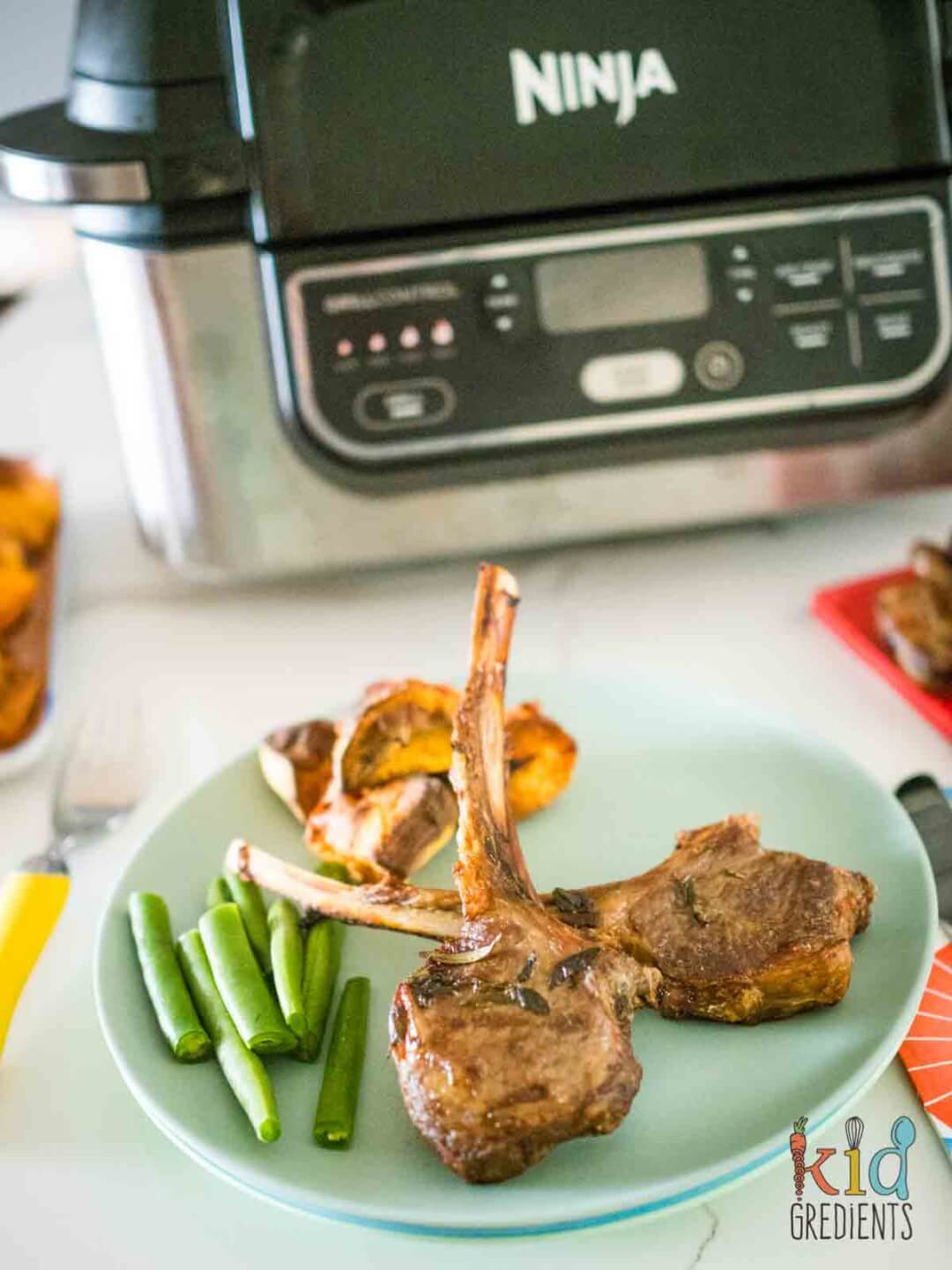 Oregano and Lemon Lamb on a plate with sweet potatoes and green beans