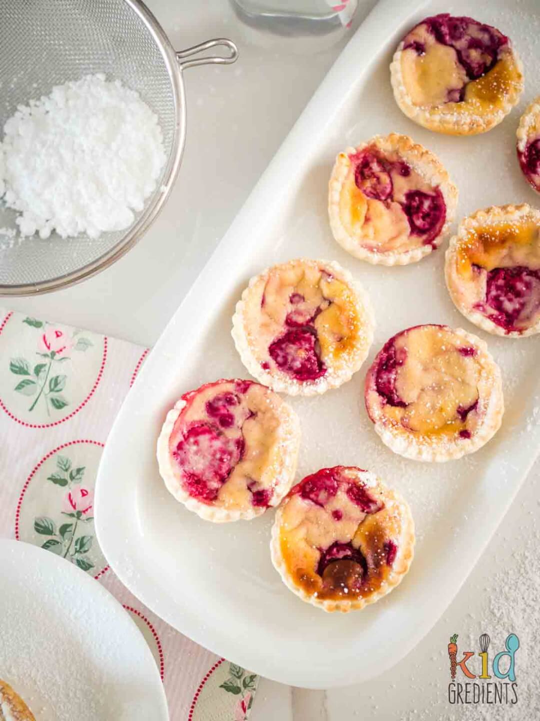 Ricotta Raspberry Tarts on a plate with icing sugar