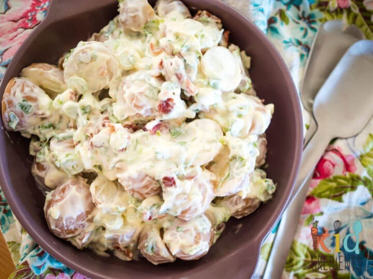 5 Ingredient Super Simple Potato Salad on a plate with salad servers next to it