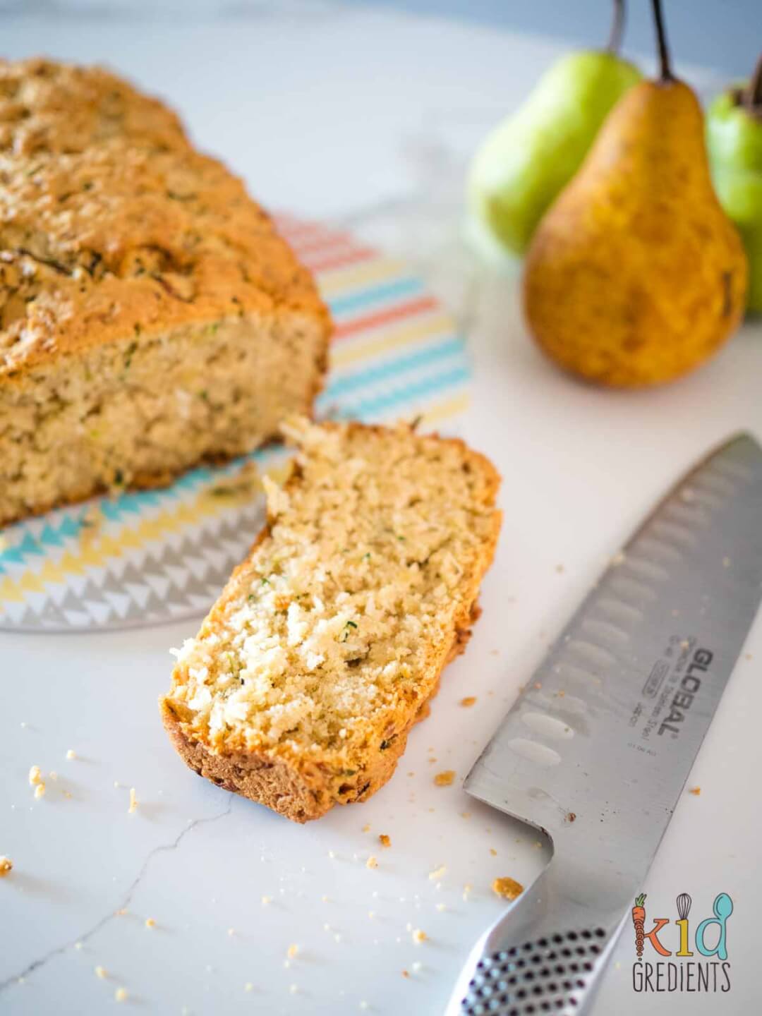 Pear and Zucchini bread sliced and whole with pears in the background.
