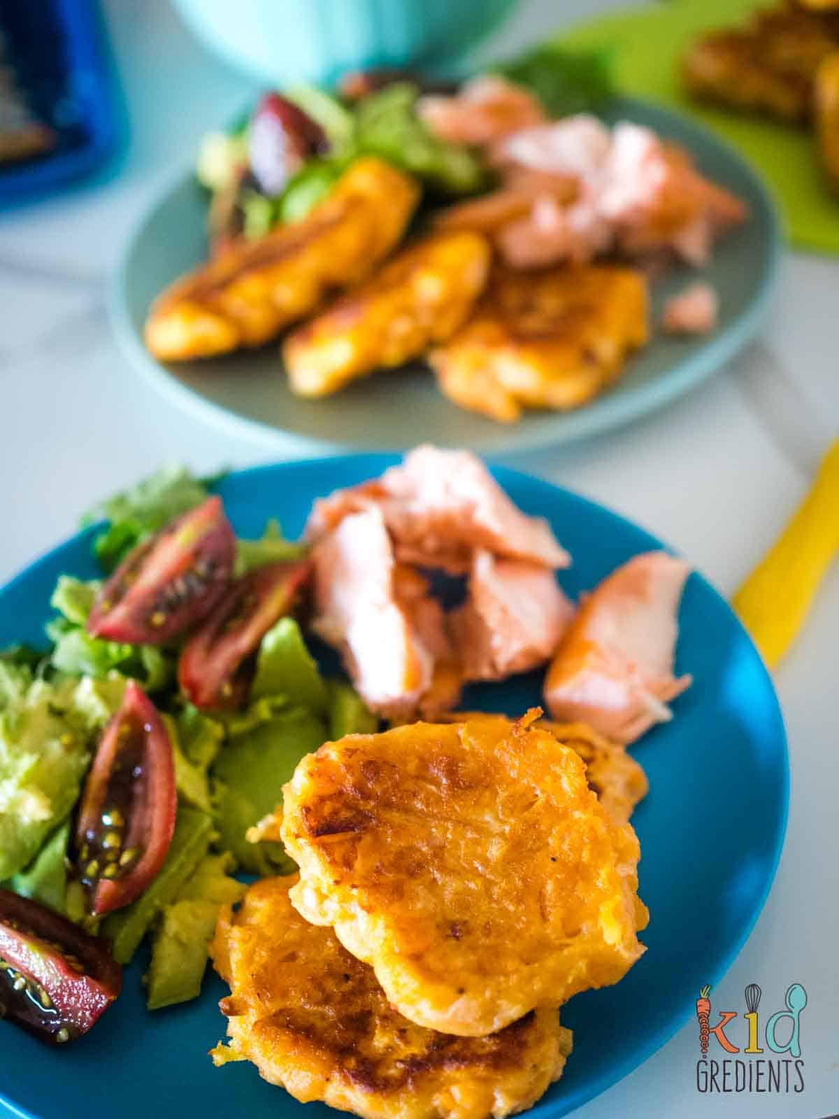 Sweet potato and apple fritters on a blue plate with salad.