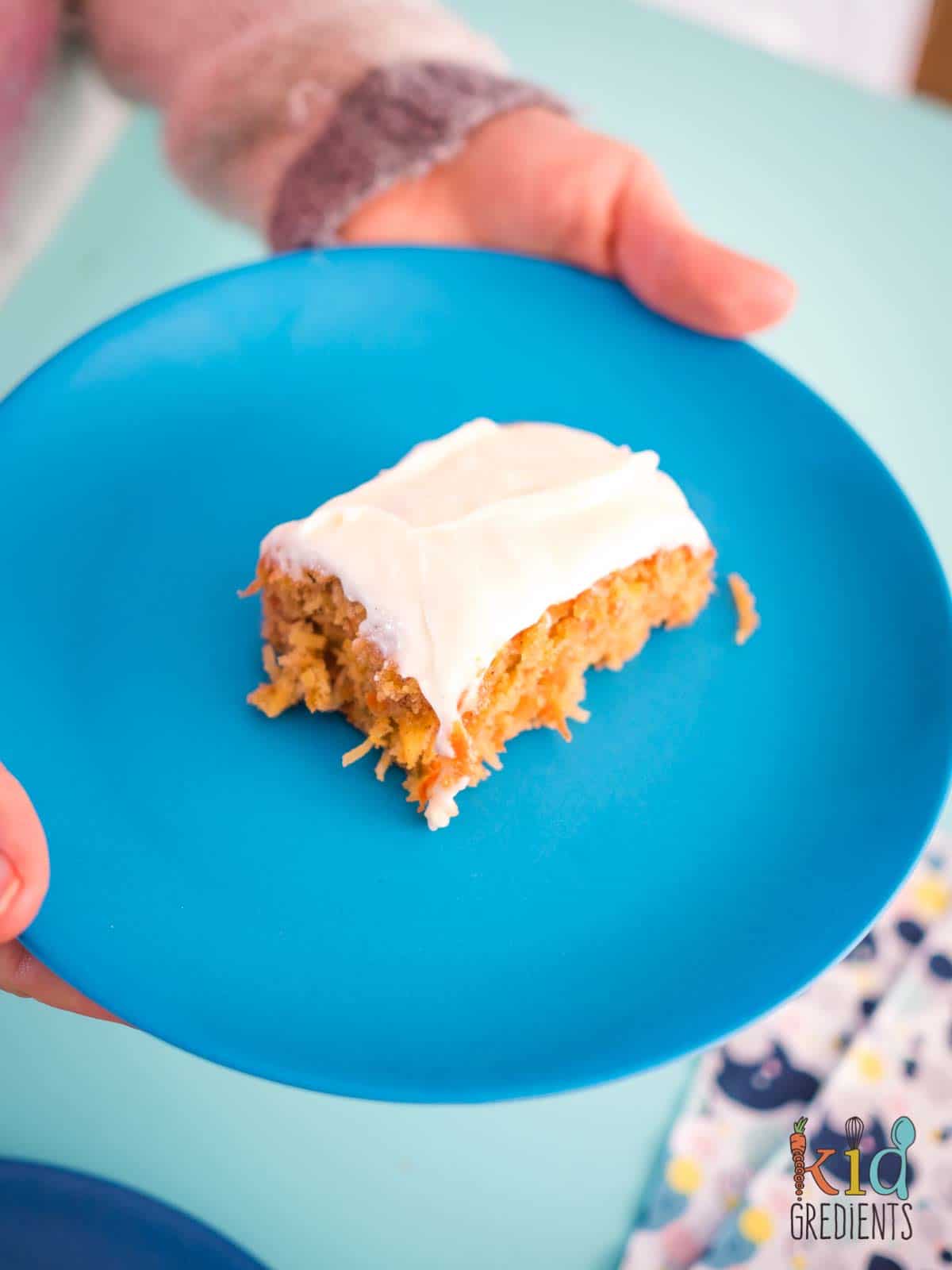 a slice of apple carrot and coconut cake on a blue plate