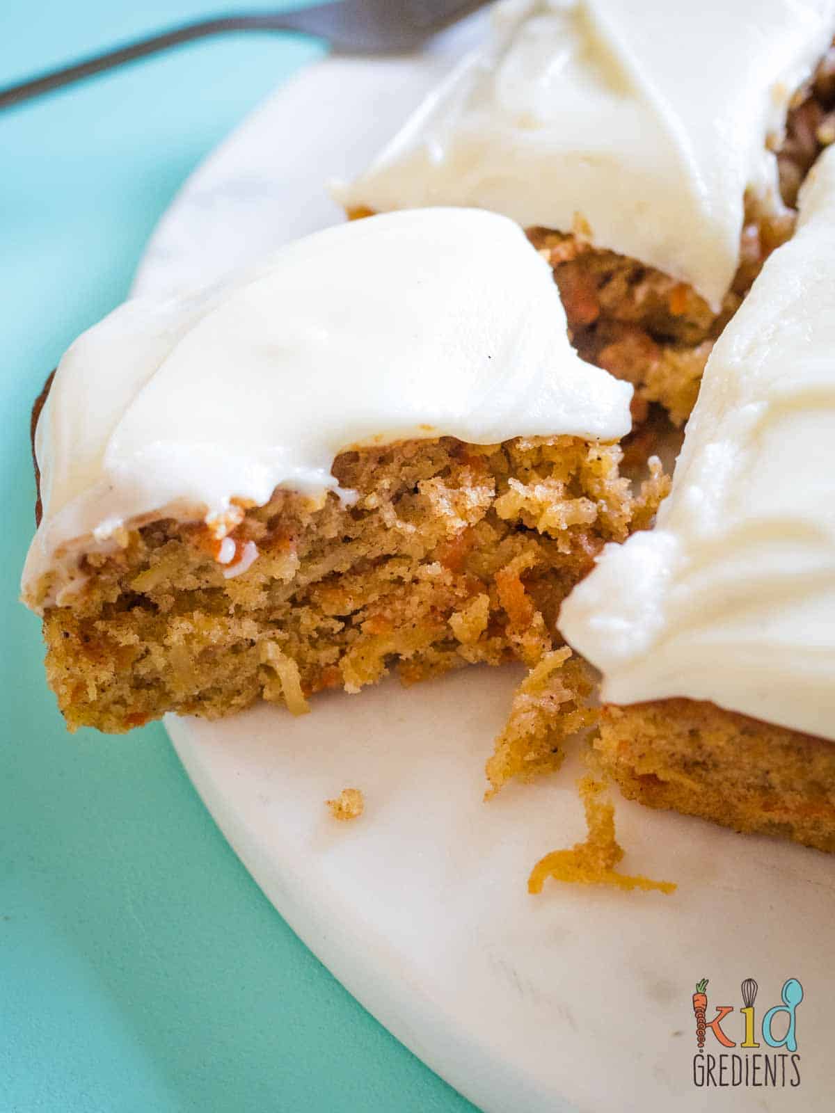 apple carrot and coconut cake cut open, iced