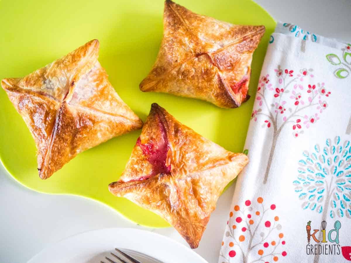 Apple and Raspberry Puff Pastry Pies on a green apple shaped chopping board