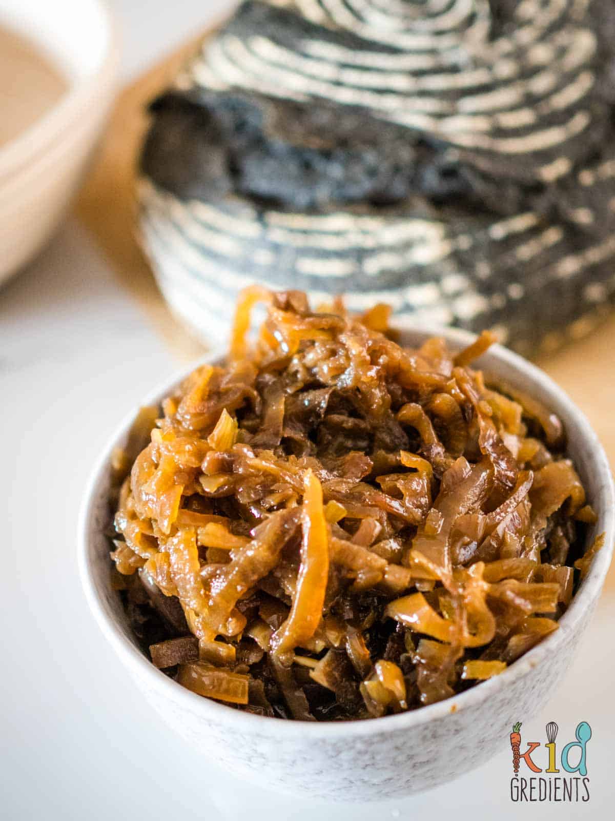 slow cooker caramelised onions in a bowl in front of sourdough