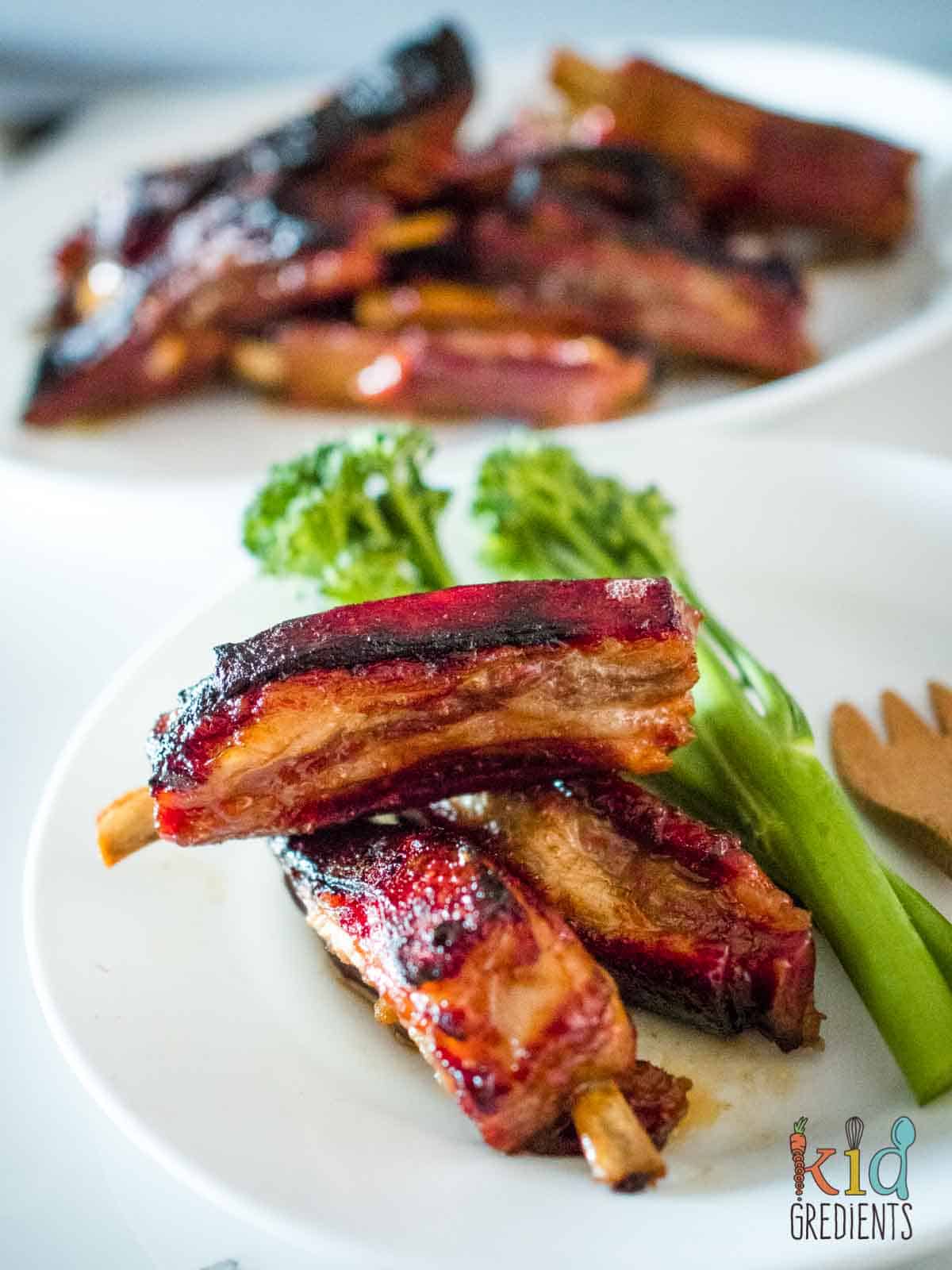 lamb riblets on a plate with broccolini