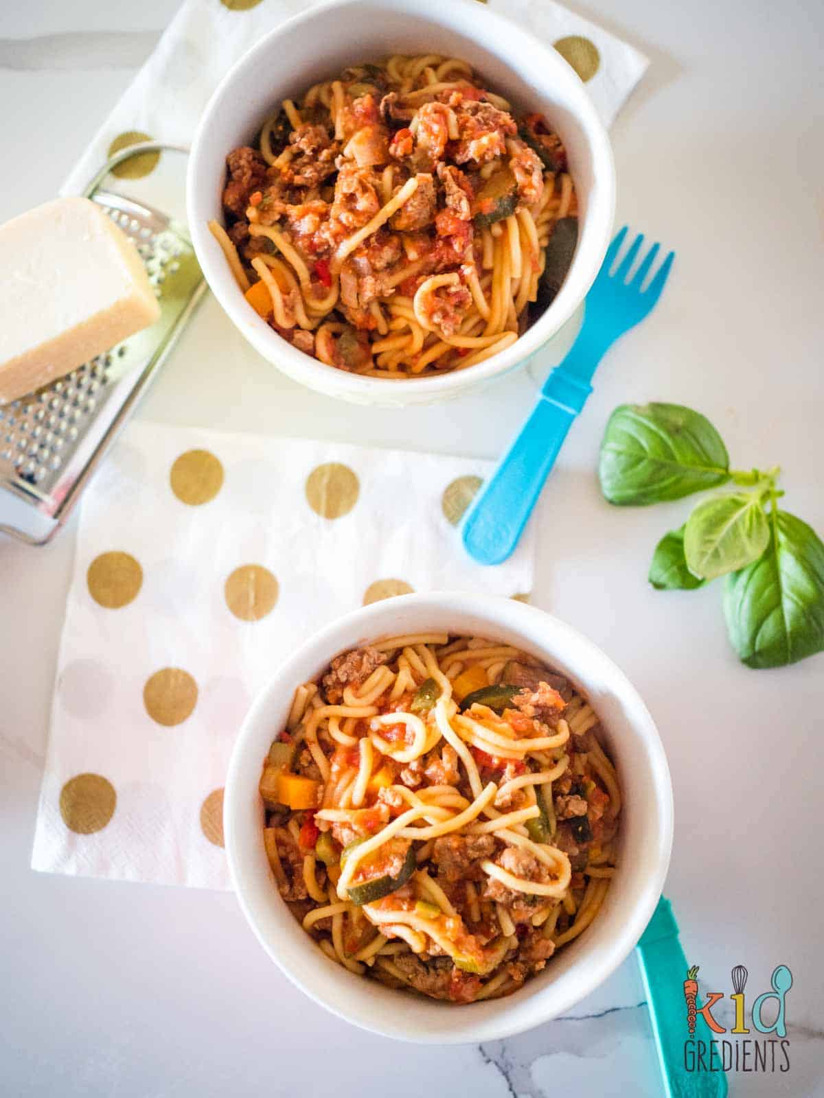 one pot healthy turkey bolognese, in two bowls, with parmesan cheese