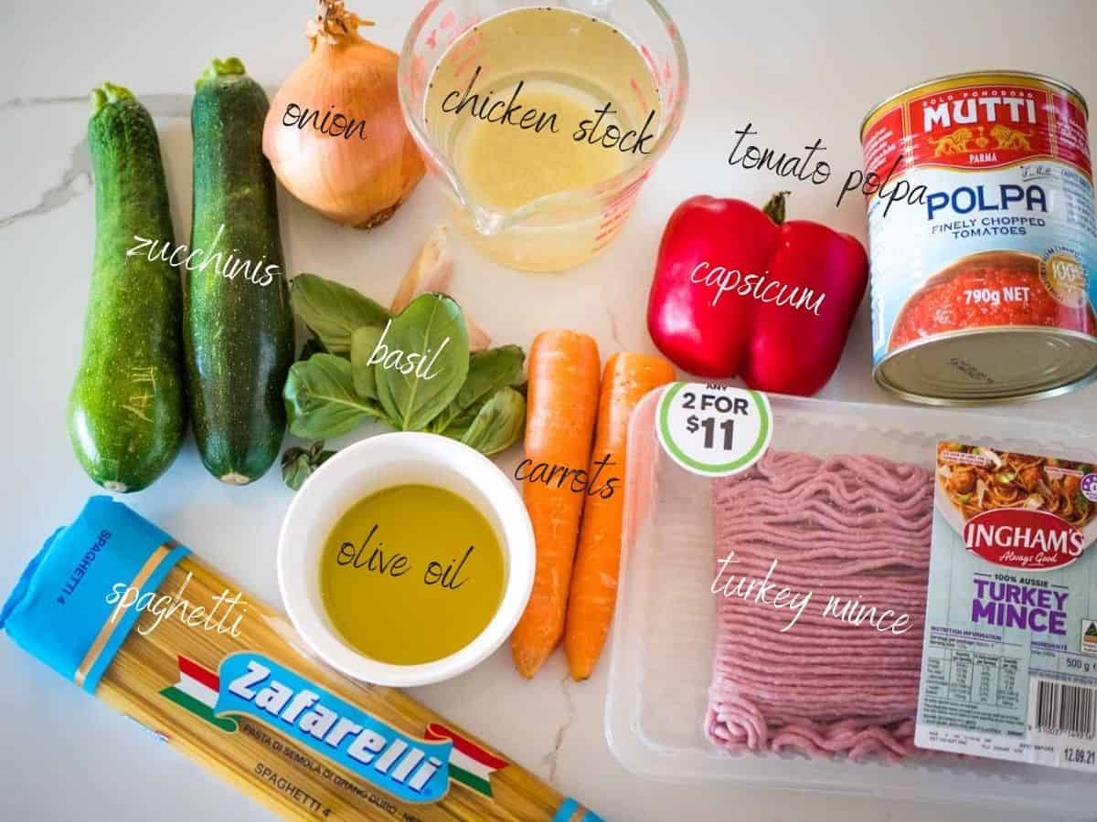 ingredients for one pot healthy turkey bolognesE: turkey mince, garlic, onion, olive oil, carrots, zucchinis, capsicum, chicken stock, tomato polpa, basil, spaghetti