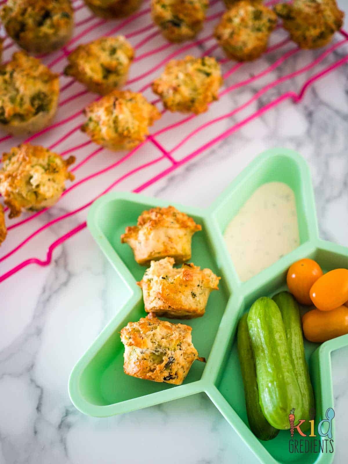 broccoli and cheese muffins on a plate with veggies