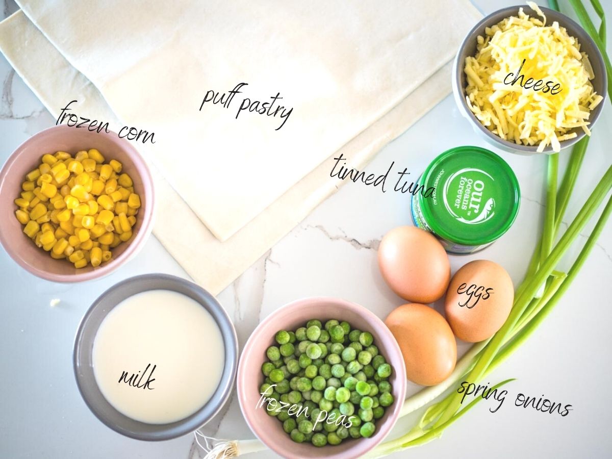 ingredients for tuna quiches: puff pastry, tinned tuna, peas, corn, spring onions, eggs and milk.