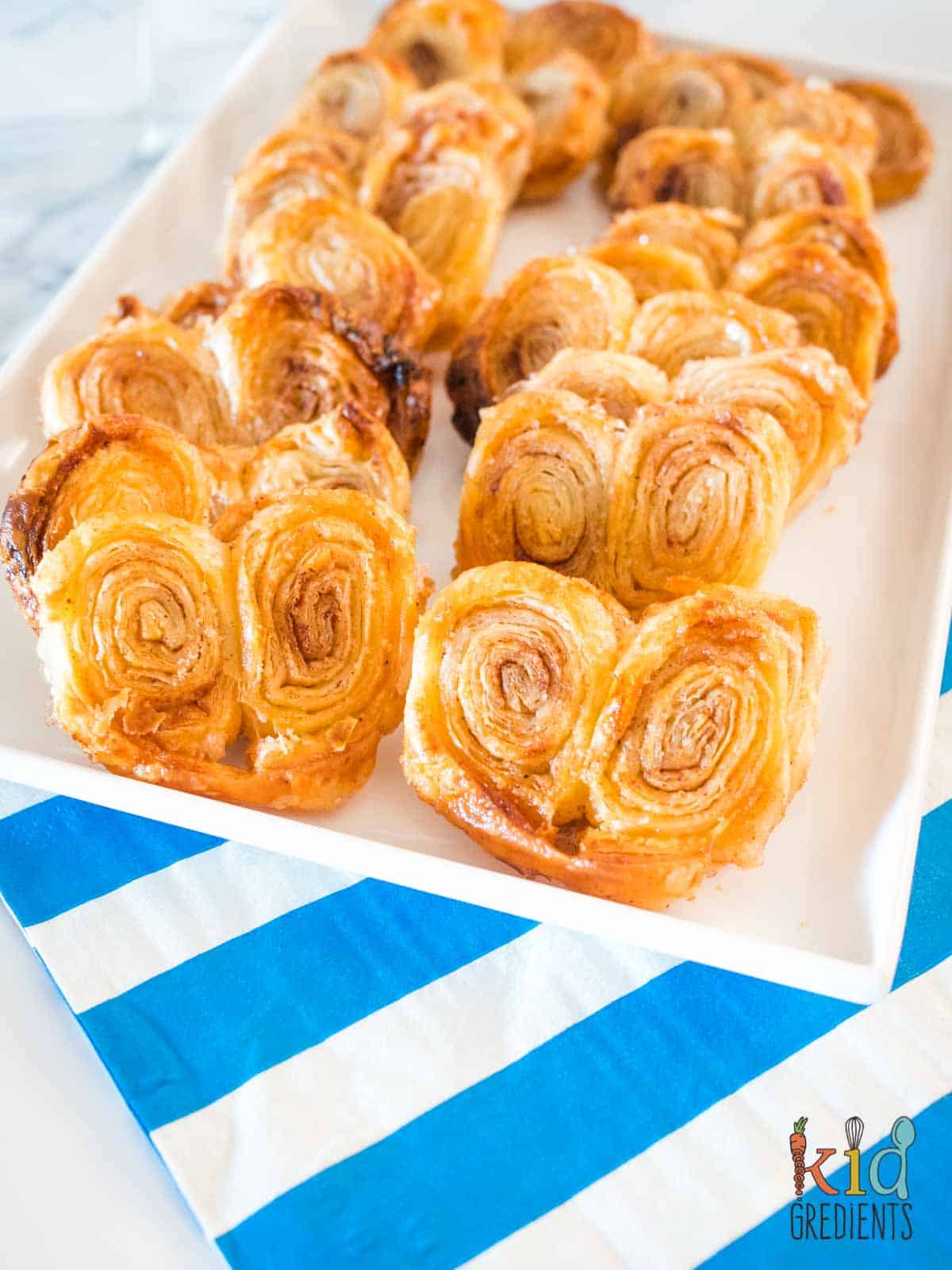 Cinnamon sugar palmiers on a plate with a blue and white napkin.