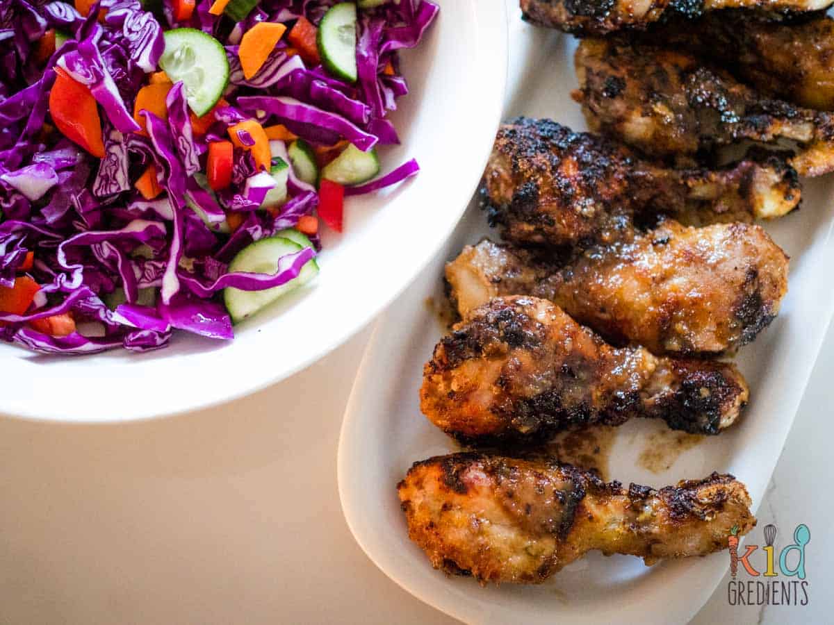 honey lime chicken drumsticks on a plate next to salad