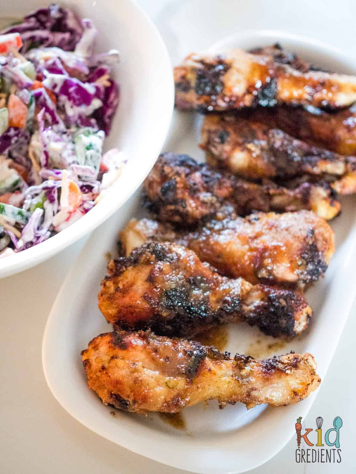 honey lime chicken drumsticks on a plate next to salad