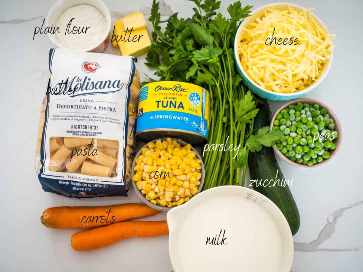 ingredients for tuna pasta bake: pasta, tuna, corn, peas, zucchini, carrots, parsley, milk, cheese butter, flour